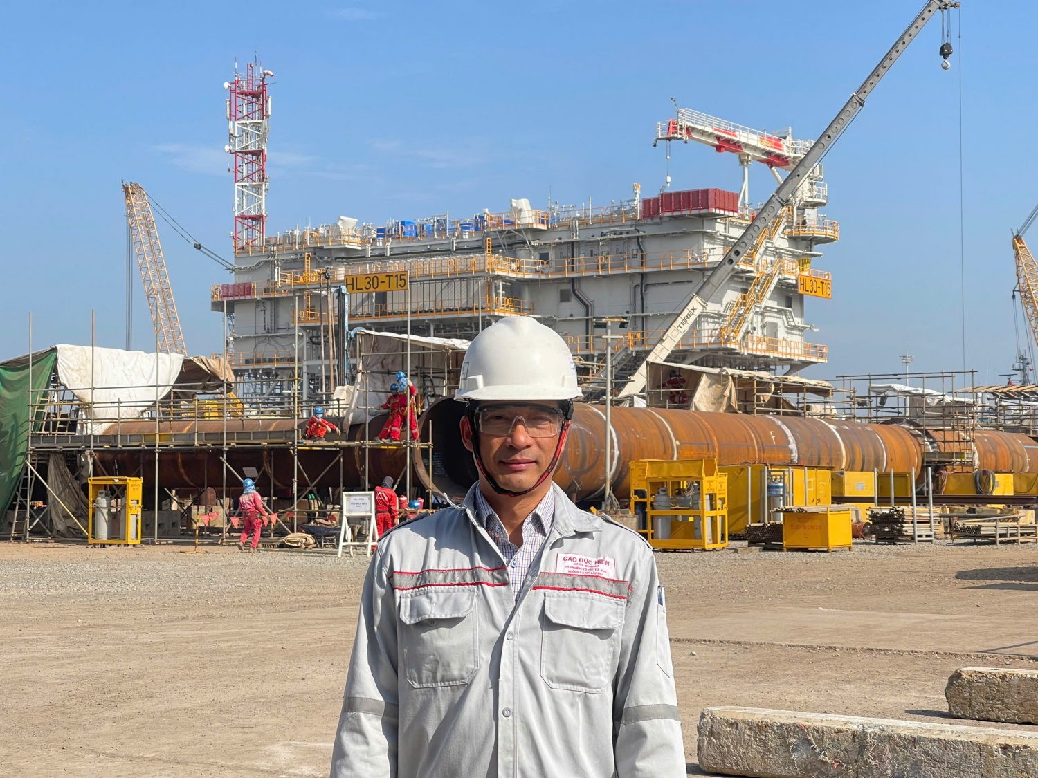 Anh Cao Đức Hiển trước công trường thi công của công ty PTSC M&C. Anh Cao Đức Hiển trước công trường thi công của công ty PTSC M&C.