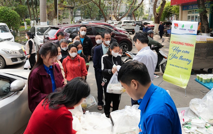 Nhiều bệnh nhân và thân nhân người bệnh xếp hàng để nhận những suất cơm từ chương trình