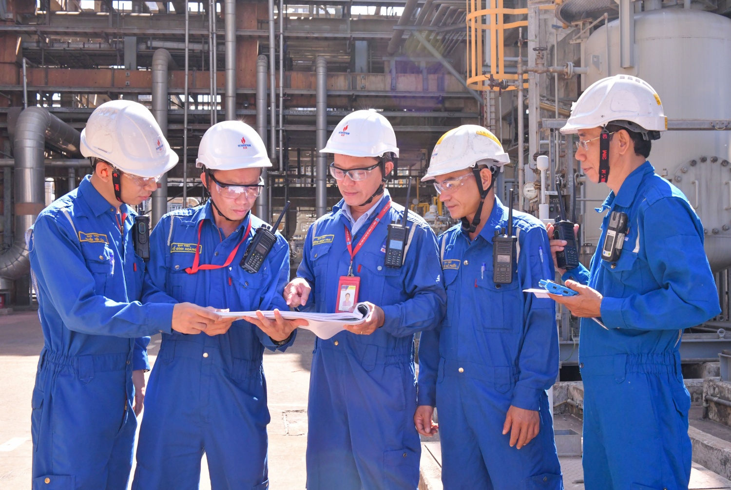 Anh Vương Ngọc Trai (đứng giữa) cùng các đồng nghiệp kiểm tra bản vẽ thông số kỹ thuật thiết bị tại hiện trường.