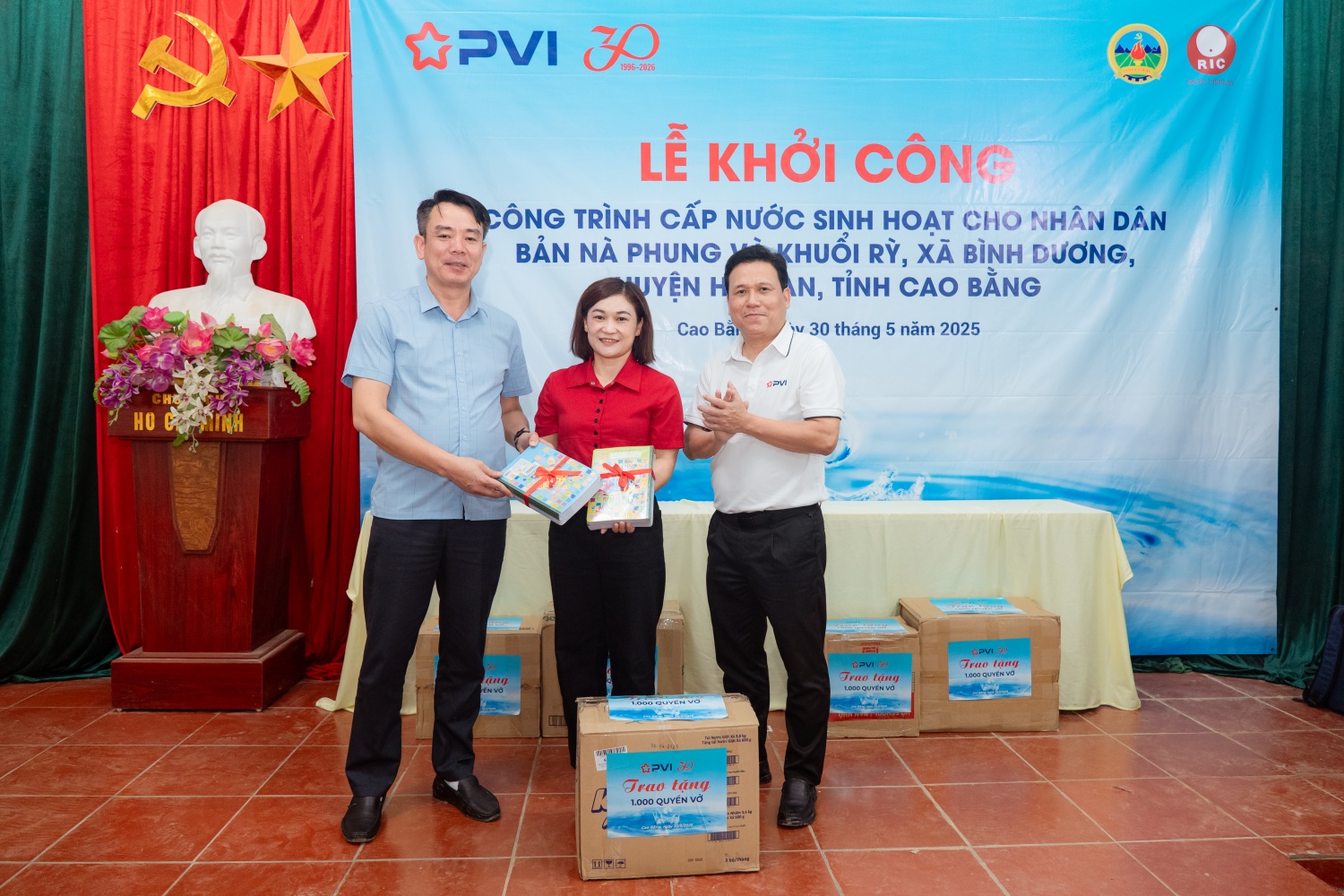 Ông Đặng Tiến Dũng - Phó Bí thư Đảng ủy, Chủ tịch Công đoàn đại diện PVI và ông Đàm Thế Trang - Phó Chủ tịch huyện Hòa An trao tặng 1.000 cuốn vở cho các em học sinh thuộc điểm Trường Tiểu học và THCS xã Bình Dương.