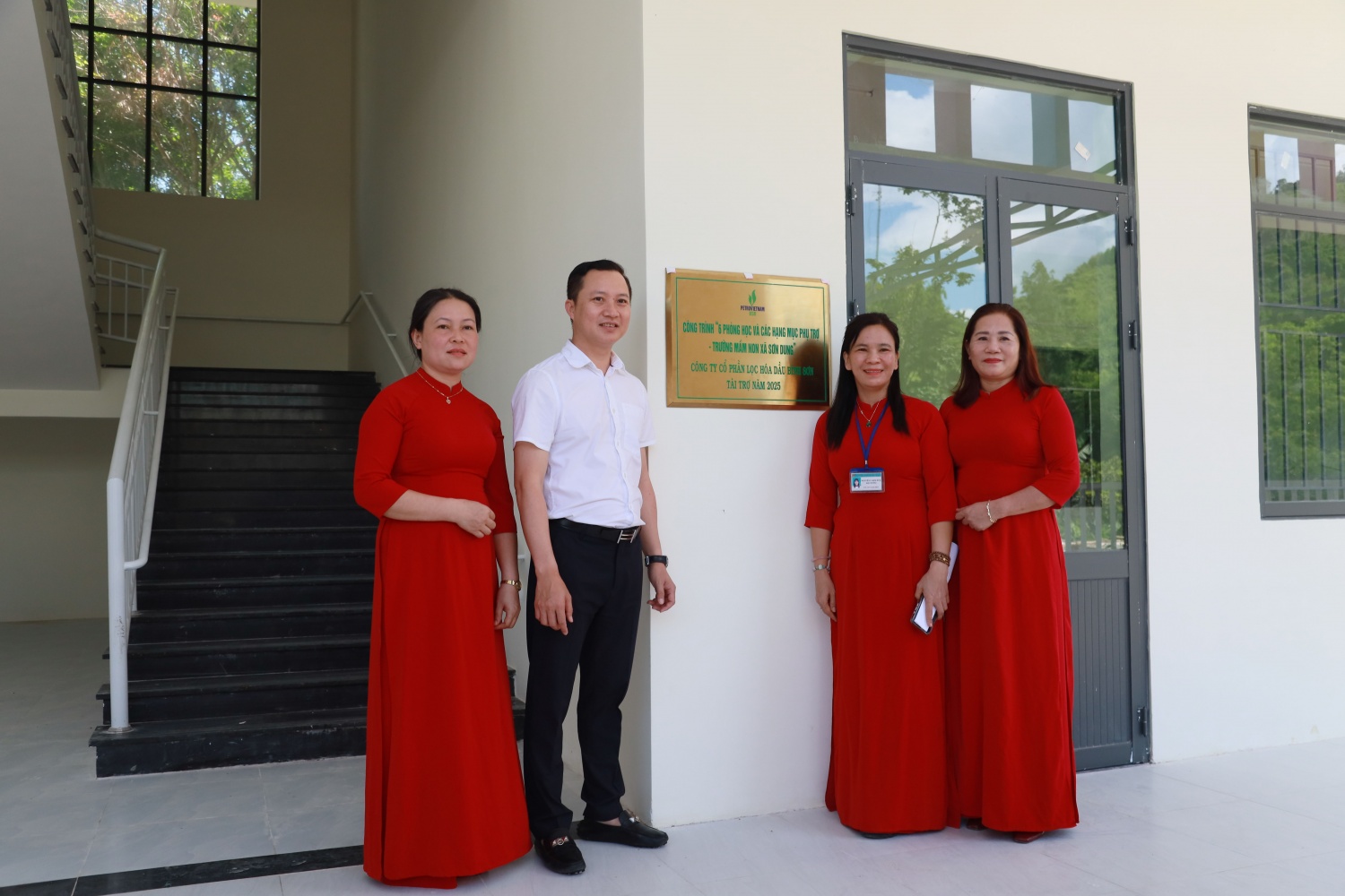 Ông Phạm Minh Nghĩa - Phó Tổng Giám đốc BSR và các cô giáo thực hiện nghi thức gắn biển tại Trường Mầm non xã Sơn Dung.