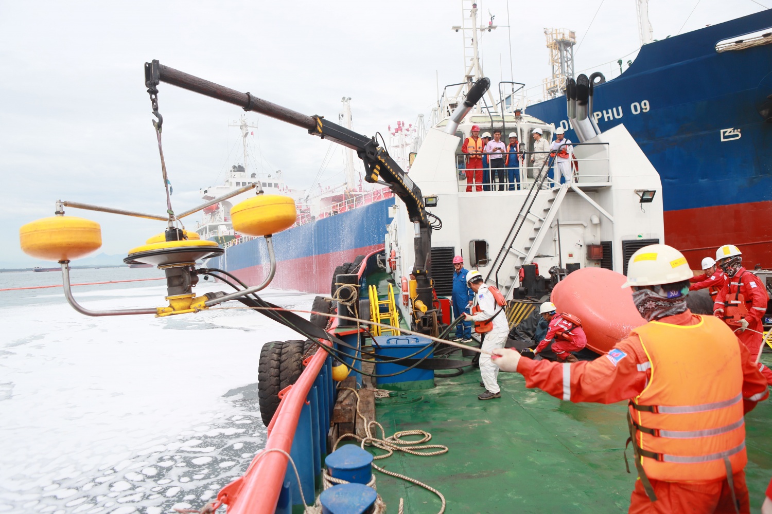Các lực lượng triển khai thiết bị hút dầu tràn và tổ chức quây phao khống chế dầu loang trên mặt biển.