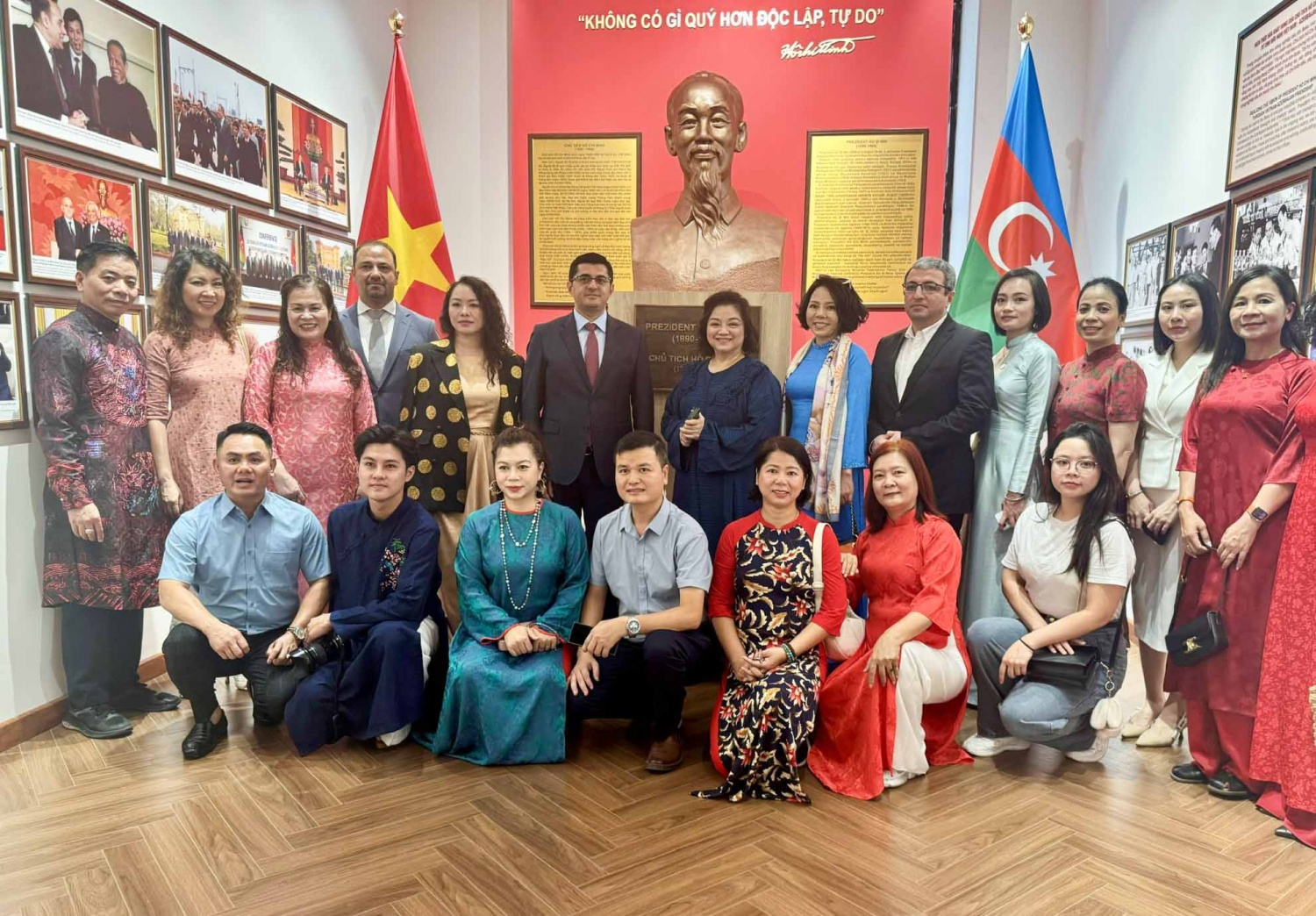 Phái đoàn chụp ảnh lưu niệm trước tượng Chủ tịch Hồ Chí Minh với câu tuyên ngôn bất hủ của Người.