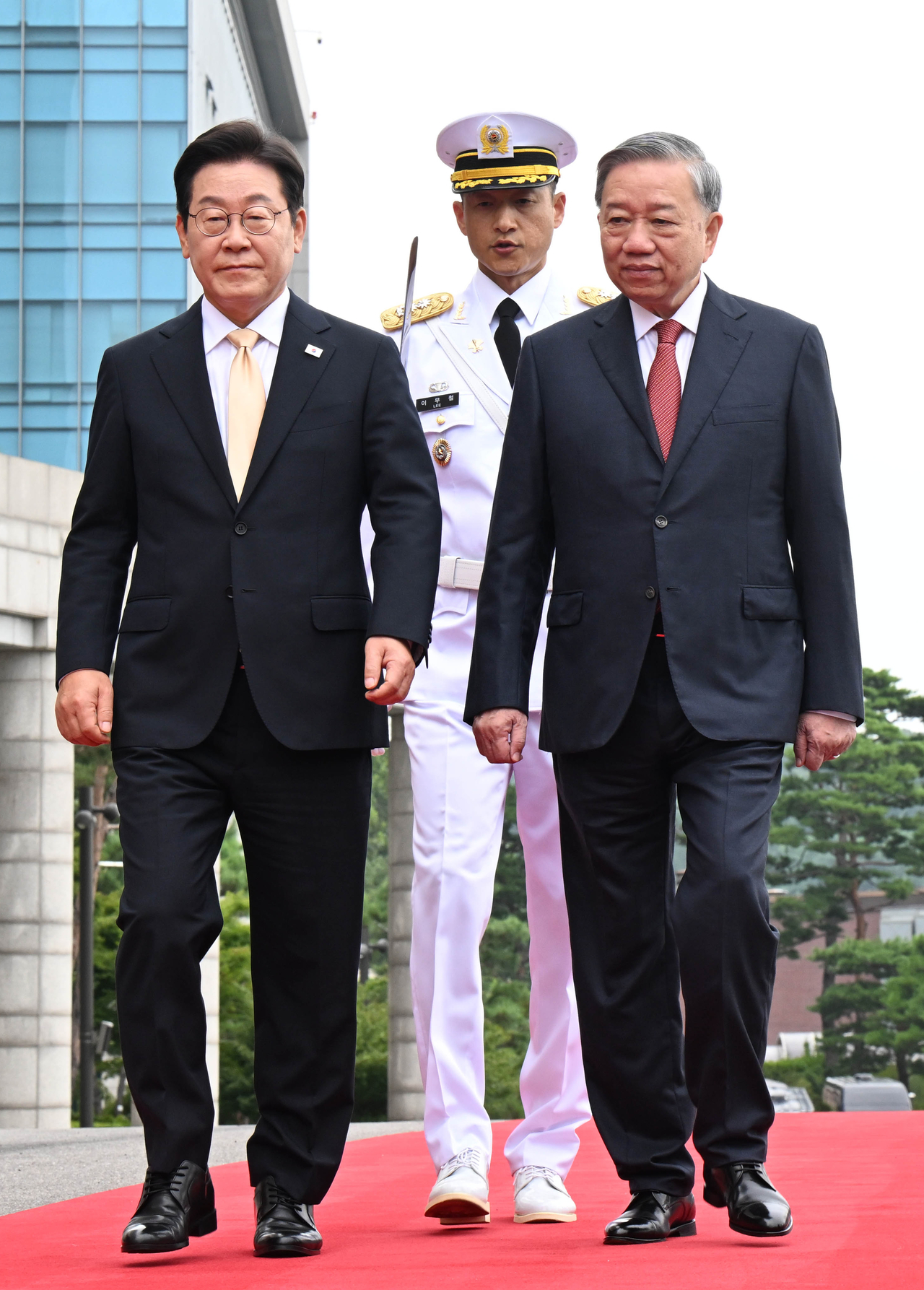 President Lee Jae Myung (left) and General Secretary of the Communist Party of Vietnam To Lam (right) walk on a red carpet as Lee receives Lam at his office in Seoul on Monday. (Pool photo via Yonhap)