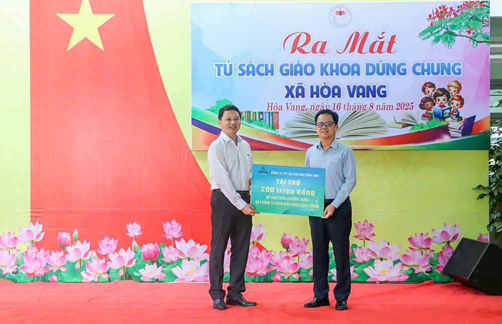 Phó Chủ tịch UBND xã Hòa Vang Hồ Tăng Phúc (bên trái) tiếp nhận biển tượng trưng tài trợ từ ông Nguyễn Văn Hội - Thành viên HĐQT BSR đại diện trao tặng.