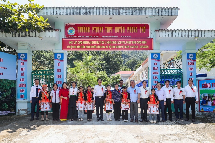 Các đại biểu cùng các em học sinh tại cổng trường trước lễ khởi công.