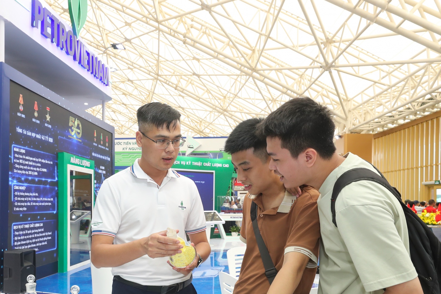 Em Nguyễn Trường Hiếu (giữa) - sinh viên năm thứ tư Khoa Kỹ thuật Hóa học, Đại học Bách khoa Hà Nội tìm hiểu các sản phẩm tại gian hàng BSR.