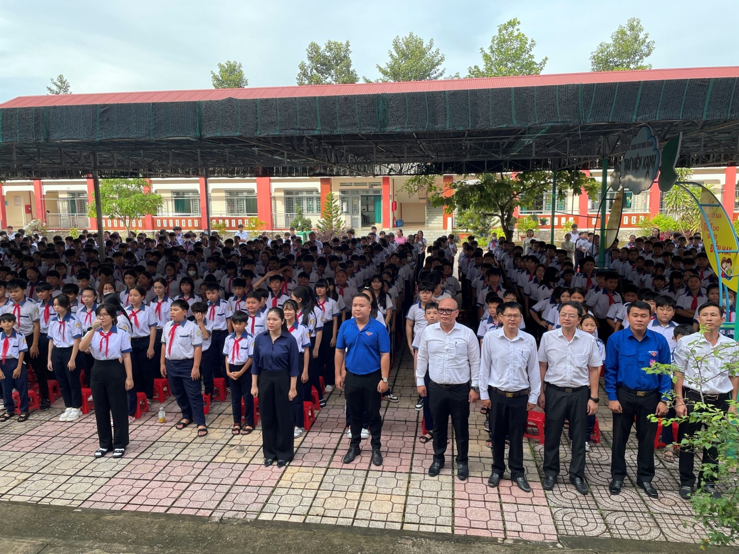 Đại biểu cùng toàn thể thầy cô giáo và các em học sinh thực hiện nghi thức chào cờ