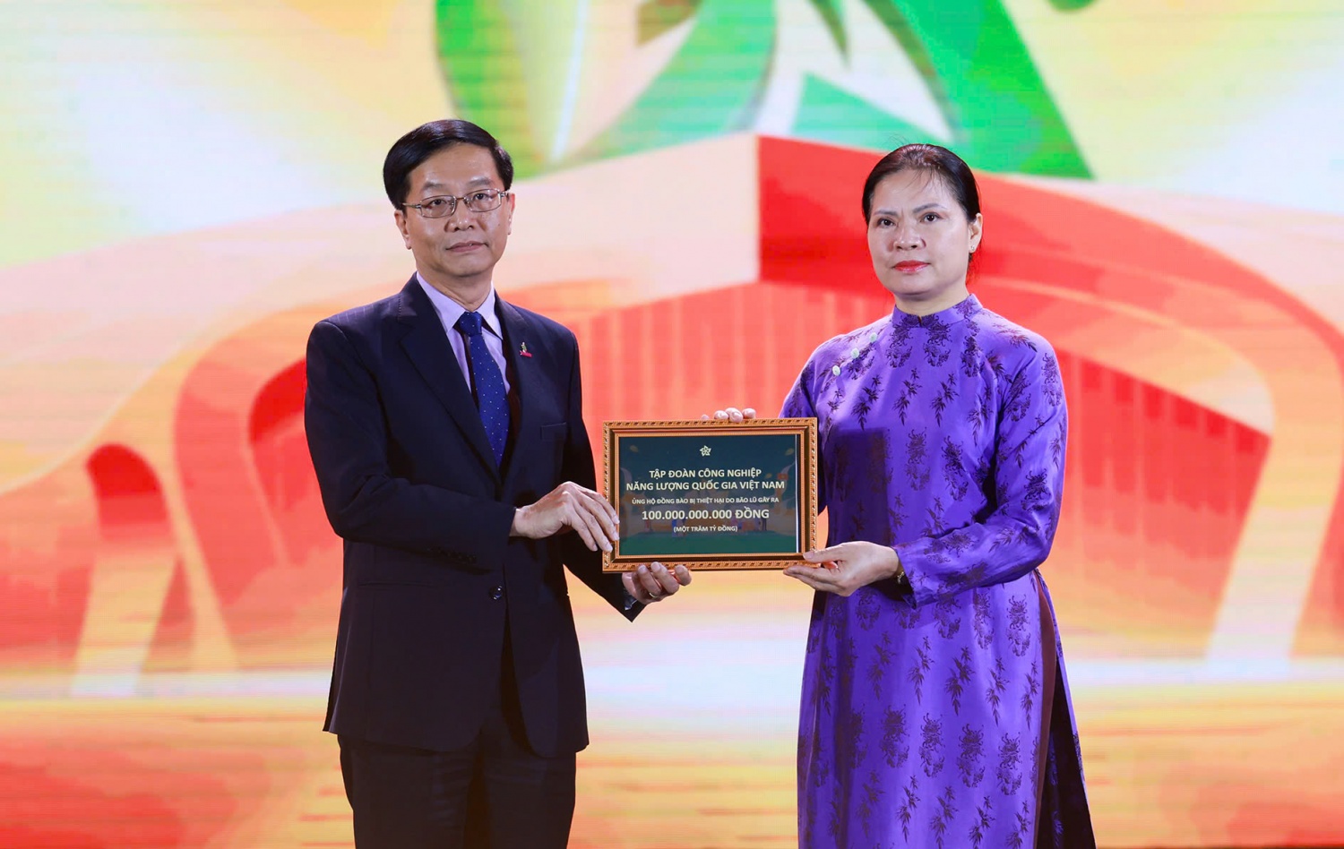 Đại diện Petrovietnam, đồng chí Trần Quang Dũng trao biểu trưng hỗ trợ cho đồng bào bị thiệt hại do bão lũ với sự tiếp nhận của đồng chí Hà Thị Nga - Phó Chủ tịch Ủy ban Trung ương Mặt trận Tổ quốc Việt Nam.