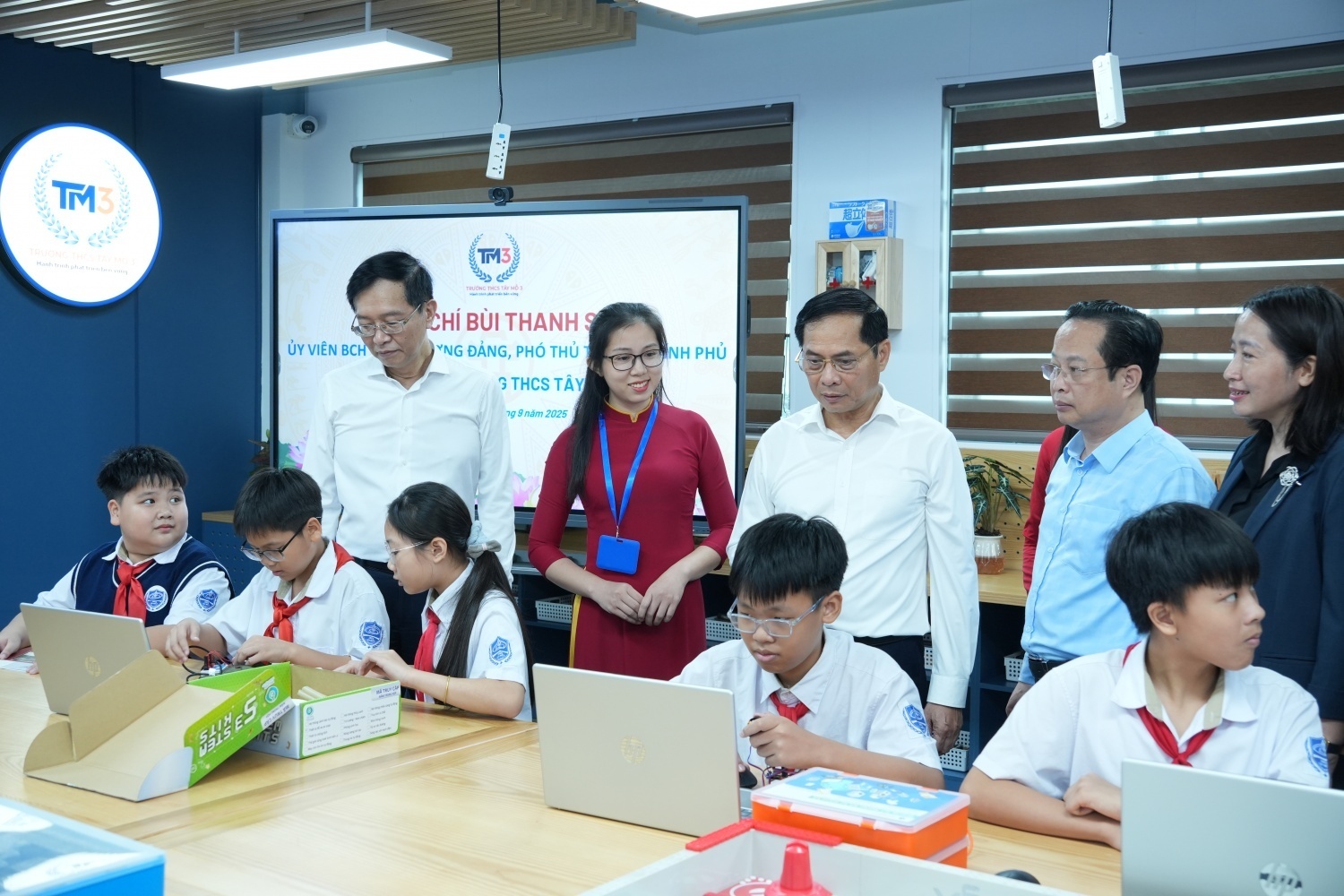 Phó Thủ tướng Bùi Thanh Sơn và đồng chí Trần Quang Dũng - Phó Bí thư thường trực Đảng ủy Petrovietnam cùng các đại biểu, thầy cô giáo xem các em học sinh Trường THCS Tây Mỗ thực hành trên các thiết bị của phòng thực hành STEM.