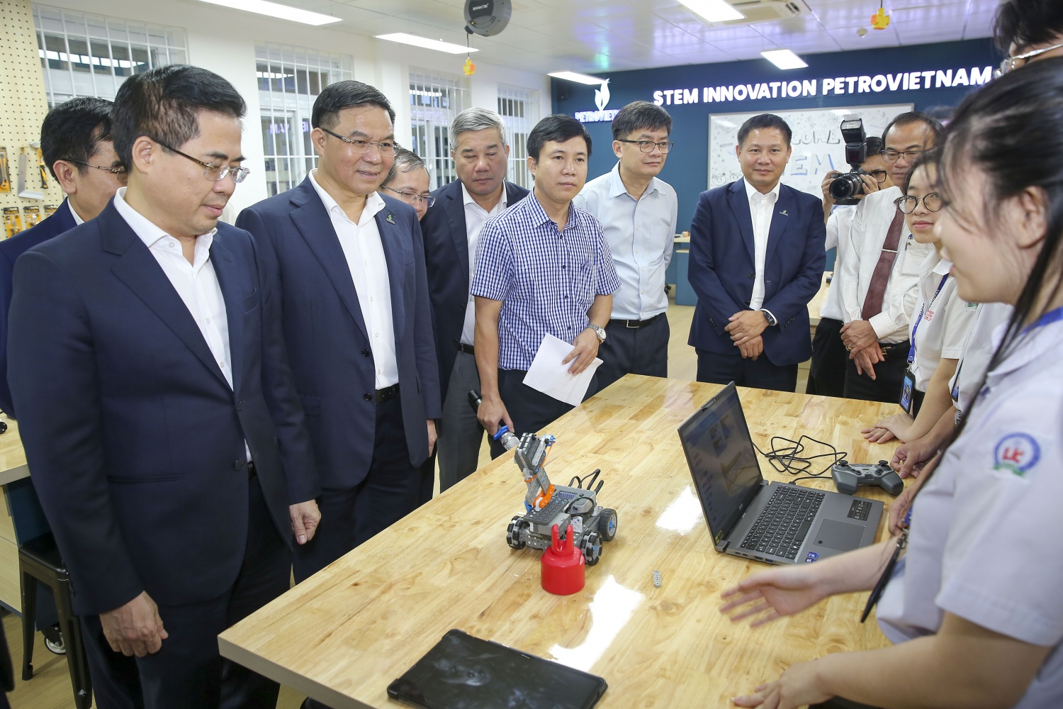 Các đại biểu trò chuyện, trao đổi về các thí nghiệm học tập của em học sinh tại Trường THPT chuyên Lê Khiết.