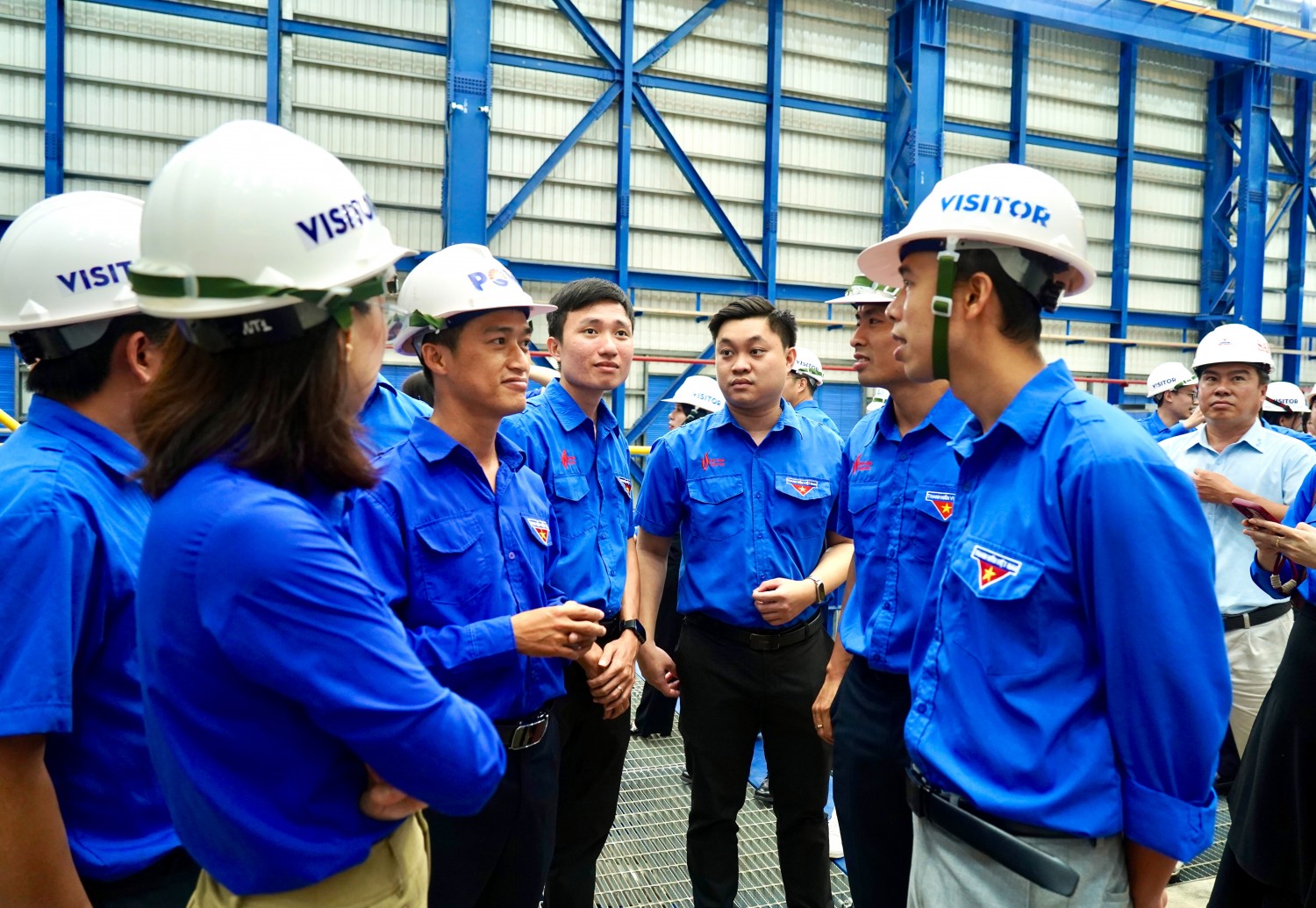 Đoàn tham quan tại khu vực nhà máy, quan sát hệ thống thiết bị và các tổ máy turbine phục vụ sản xuất điện.